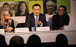 Serik Tokbolat, a Representative of the Bahá’í International Community, speaks on a panel at the UN Climate Change Conference in Paris, discussing community resilience in the face of climate-driven extreme events.